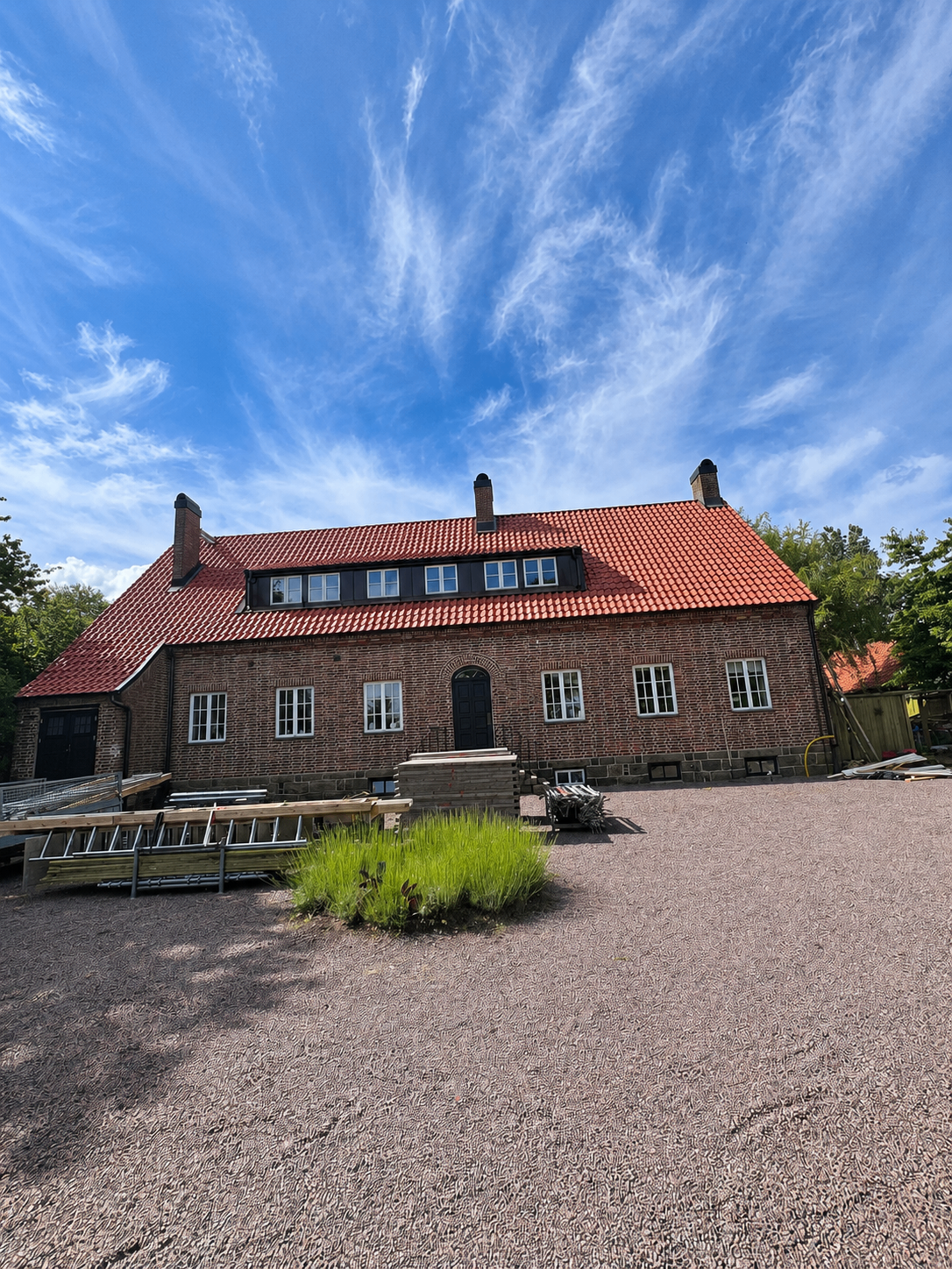 Tak efter färdigställande med nytt rött tegeltak på tegelbyggnad.
